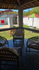 een veranda met 2 stoelen en een parasol bij Casa Laser praia Cumbuco in Cumbuco
