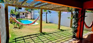 a patio with a hammock and a yard with a pool at Casa piscina Atlantida in Atlántida +8 photos