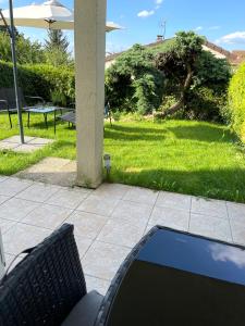 un ordenador portátil sentado en una silla en un patio en Studio cosy indépendant avec Jardin à Osny proche Cergy pontoise en Osny