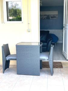 - une table et des chaises en osier sur la terrasse dans l'établissement Studio cosy indépendant avec Jardin à Osny proche Cergy pontoise, à Osny