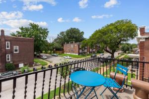 a balcony with two chairs and a blue table at Chic 4-Bed Home near Attractions - JZ Vacation Rentals in Soulard