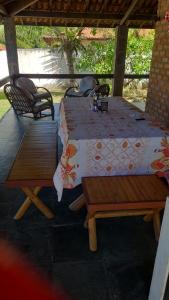 een tafel en twee banken op een patio bij Casa Laser praia Cumbuco in Cumbuco