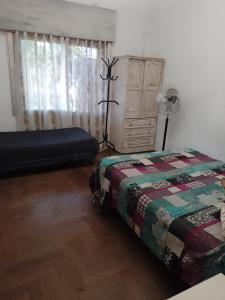 - une chambre avec un lit et une commode dans l'établissement Hostel La Tana, à Lomas de Zamora
