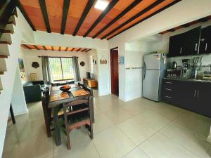 eine Küche mit einem Tisch und einem Kühlschrank in der Unterkunft Casa piscina Atlantida in Atlántida