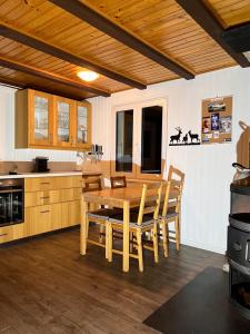 eine Küche mit einem Holztisch und Stühlen in der Unterkunft Le Joly Chalet in Saint-Imier