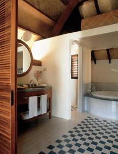 a bathroom with a tub and a sink and a mirror at Holiday Inn Resort Vanuatu, an IHG Hotel in Port Vila