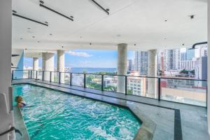 une femme assise dans une piscine dans un bâtiment dans l'établissement Panoramic Views of City and Bay from this Studio, à Miami