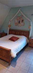 a bedroom with a large bed with a wooden headboard at La Forge De Labbaye in Liessies