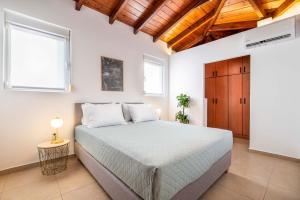 a bedroom with a large bed and two windows at Aeolos Loft - 3 min Walk to Beach & Town in Kos
