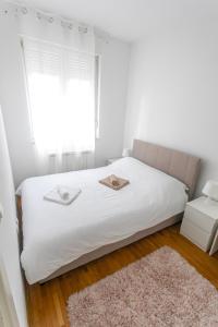 a bedroom with a bed with white sheets and a window at ANAMARIE Apartment, free parking, Belgrade, Center, SRB in Vračar (historical)