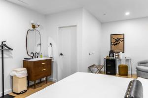 a white bedroom with a bed and a mirror at The Phenix Historic DTWN Hotel, King Bed, Room # 311 in Bangor