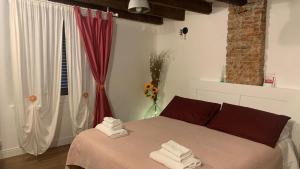 1 dormitorio con 1 cama con toallas en CASA CIMELLA, un nido nel cuore del porto antico cod CITRA 010025-LT-2629, en Génova