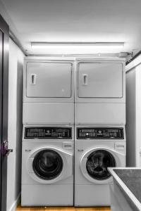 four washers and dryers are stacked in a kitchen at The Phenix Historic DTWN Hotel, King Bed, Room # 311 in Bangor