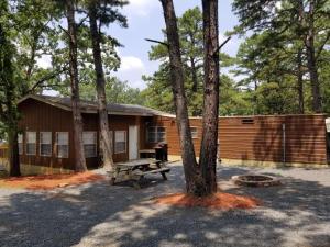a cabin with a picnic table in front of a tree at Southern Comfort Inn & Resort in Fairfield Bay