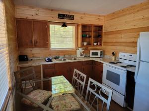a kitchen with wooden cabinets and a white stove top oven at Southern Comfort Inn & Resort in Fairfield Bay +26 photos