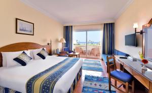 a hotel room with a bed and a desk at Bliss Nada Beach Resort in Coraya Bay