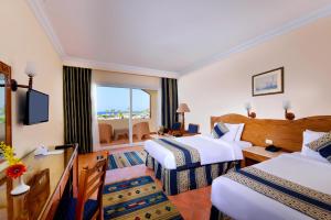 a hotel room with two beds and a window at Bliss Nada Beach Resort in Coraya Bay