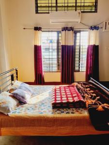 1 dormitorio con 1 cama con cortinas rojas en Upasana Homestay, en Dibrugarh