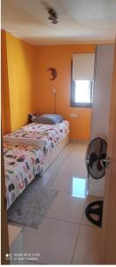 a bedroom with a bed and a yellow wall at Apartamento Neptuno in Candelaria