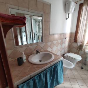 y baño con lavabo y aseo. en La Casa di Paolo, en Terralba