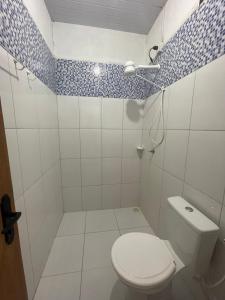a white bathroom with a toilet and a shower at Sítio Paraíso do Caju in Barreirinhas