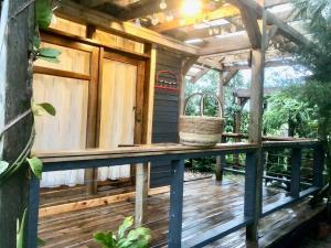 une terrasse en bois avec une pergola et un panier dans l'établissement The Rustic Gorilla Cabin-Bwindi, à Kinkizi