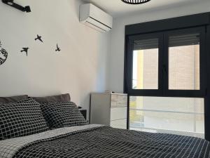 a bedroom with a bed and a window with birds on the wall at Apartamento en Roquetas de Mar. in Aguadulce