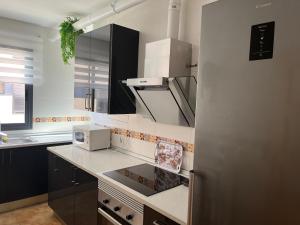 cocina con fregadero y fogones horno superior en Apartamento en Roquetas de Mar., en Aguadulce