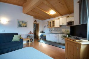 a living room with a blue couch and a kitchen at Apartments Dolina in Ortisei