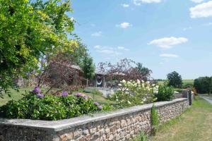 a stone retaining wall in a garden with flowers at La Terrade in Saint-Hilaire-La-Treille +32 photos