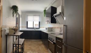 eine Küche mit schwarzen und weißen Schränken und einem Waschbecken in der Unterkunft Apartamento en Roquetas de Mar. in Aguadulce