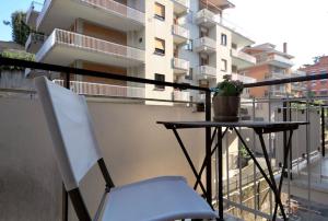 einen Tisch und einen weißen Stuhl auf dem Balkon in der Unterkunft Le 3 Elle Vaticano San Pietro in Rom