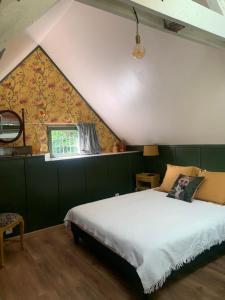 una camera da letto con un grande letto in mansarda di Bed and Breakfast à Rochefort-en-Terre a Rochefort-en-Terre