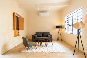 a living room with a couch and a chair at Casa Tsapot in Mérida