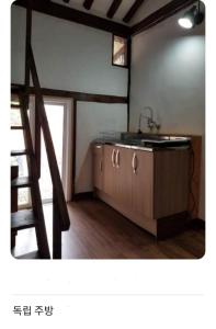 a kitchen with a sink and a wooden cabinet at Seoneulgimunhwa in Yeongju