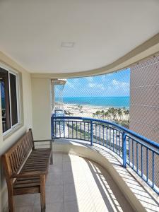 a bench on a balcony with a view of the beach at Apartamento Beach Village Praia do Futuro by WL Temporada in Fortaleza