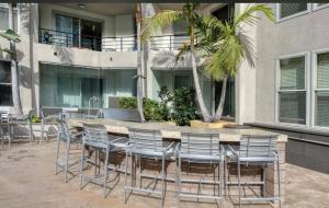 a patio with a table and chairs in front of a building at Spacious and Central with a Pool View in Los Angeles