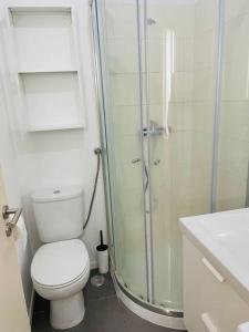 uma casa de banho com um WC e uma cabina de duche em vidro. em RSRC Central & Bright 1BR apartment em Lisboa