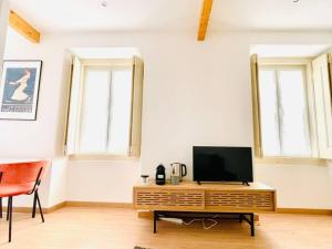 uma sala de estar com televisão numa mesa de madeira em RSRC Central & Bright 1BR apartment em Lisboa