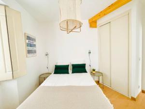 um quarto com uma grande cama branca com almofadas verdes em RSRC Central & Bright 1BR apartment em Lisboa