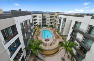 an apartment complex with a swimming pool and palm trees at Spacious and Central with a Pool View in Los Angeles