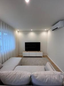 ein Wohnzimmer mit 2 Betten und einem Flachbild-TV in der Unterkunft Brittos Home Lovely Stay - Villa Family in VN Famalicão in Vila Nova de Famalicão