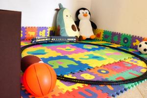 dos pingüinos disecados y un tren de juguete en una alfombra en Jacobs Resort 4 Bedroom Private House, en Kranjska Gora