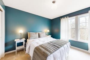 a blue bedroom with a bed and a window at Pine Crest in Pocono Pines