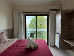 a bedroom with a teddy bear sitting on a bed at Hotel Aconchego do Velho Chico in Piranhas