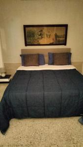 a bedroom with a large bed with blue pillows at GI&SA in Gallipoli