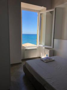a bedroom with a bed and a large window at La casetta di Marta sul mare in Imperia