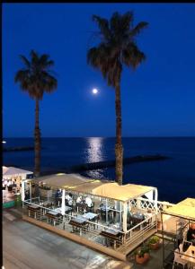 a resort with palm trees and the ocean at night at La casetta di Marta sul mare in Imperia