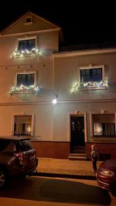 a white building with christmas lights on the windows at Pension Altsprucke in Guben