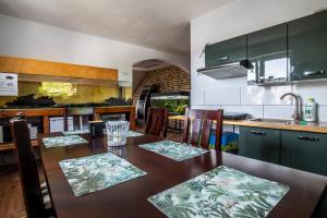 a kitchen with a wooden table with chairs and a dining room at Jurajskie Manowce in Niegowa